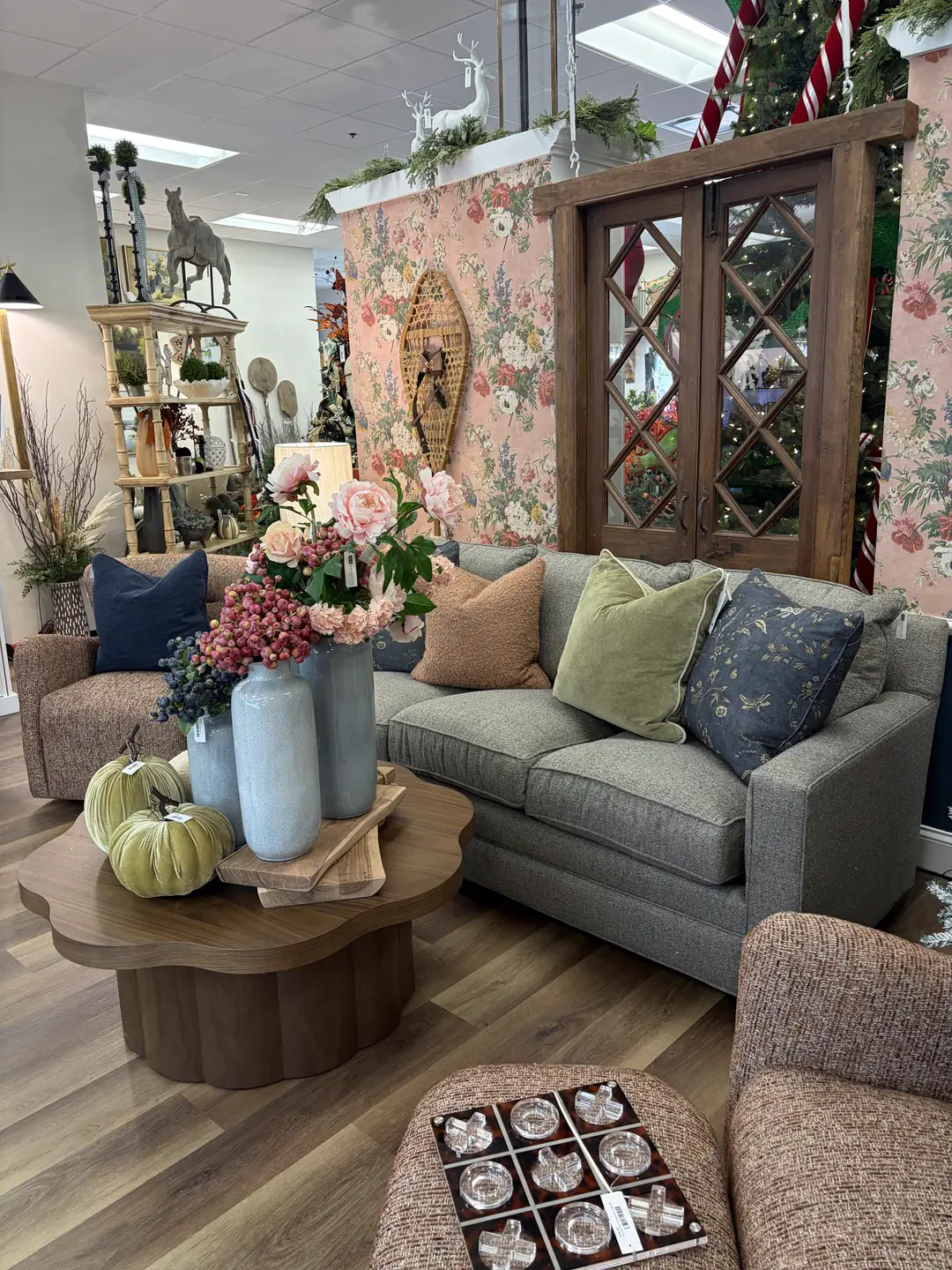 A sage sofa, pumpkins and pink florals in the floral-wallpaper corner